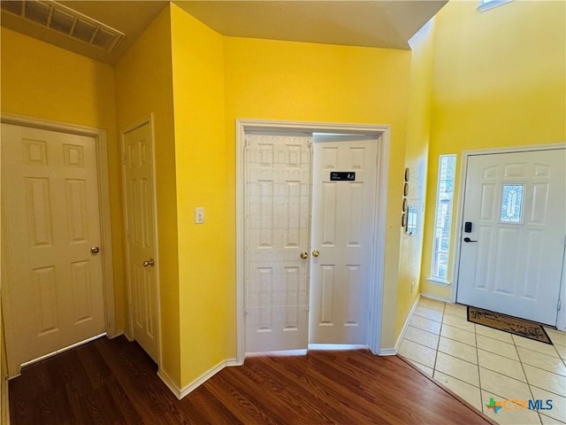 foyer with visible vents, baseboards, and wood finished floors