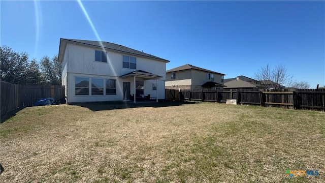 back of house featuring a yard and a fenced backyard