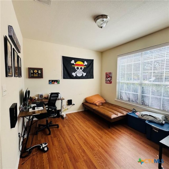 office space featuring a textured ceiling, wood finished floors, and baseboards