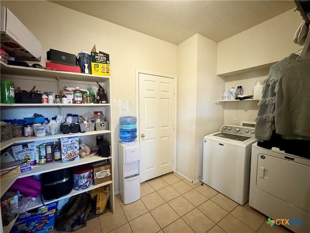 laundry area with washer and dryer, laundry area, and light tile patterned flooring