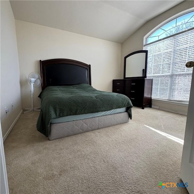 bedroom with light carpet, baseboards, and lofted ceiling