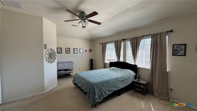 bedroom with visible vents, vaulted ceiling, a ceiling fan, and light colored carpet