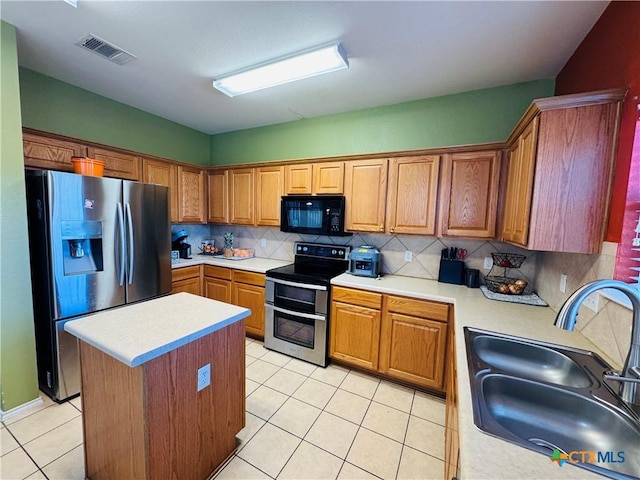 kitchen with a sink, visible vents, light countertops, appliances with stainless steel finishes, and brown cabinets