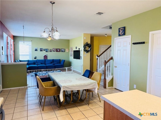 dining area featuring stairs, light tile patterned floors, and visible vents