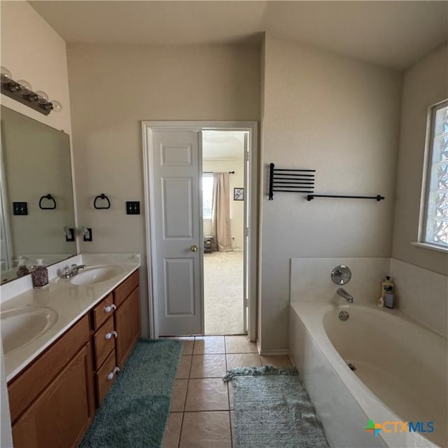 full bathroom with tile patterned flooring, a garden tub, a sink, and double vanity