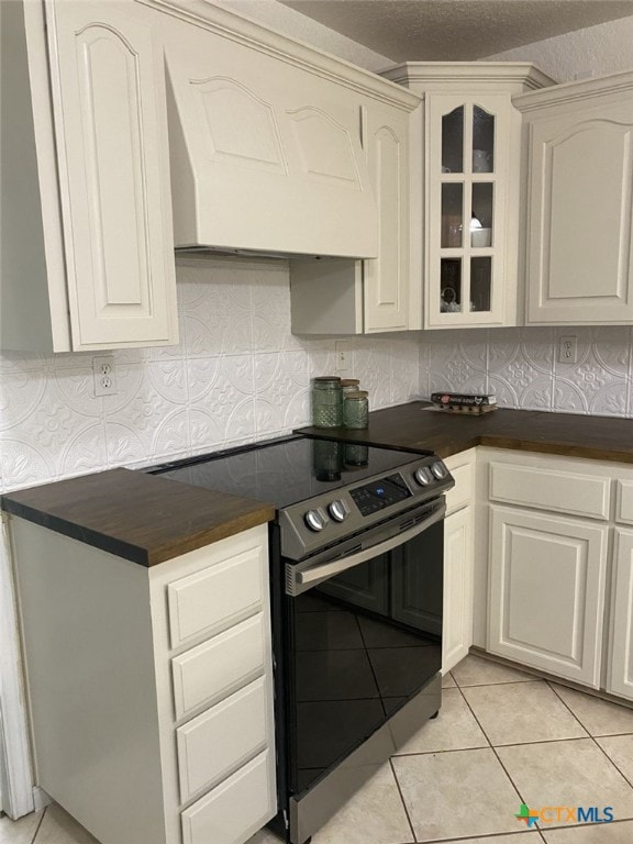 953 County Road 3351, Kempner, TX 76539 - kitchen featuring stainless steel electric range oven, dark countertops, glass insert cabinets, and premium range hood
