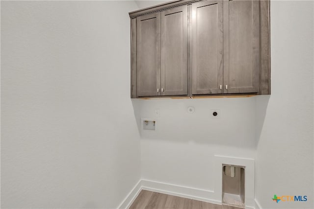 2318 Healy Dr, Temple, TX 76502 - washroom with hookup for an electric dryer, cabinet space, baseboards, light wood-style floors, and washer hookup