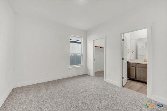 2318 Healy Dr, Temple, TX 76502 - unfurnished bedroom with light carpet, baseboards, a spacious closet, ensuite bathroom, and a sink