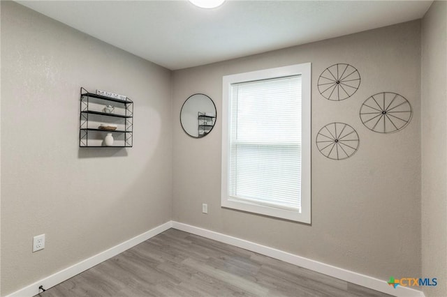 unfurnished room featuring baseboards and wood finished floors
