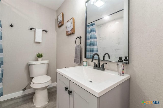 full bathroom with vanity, toilet, baseboards, curtained shower, and wood finished floors