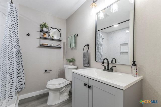 bathroom featuring vanity, toilet, curtained shower, and wood finished floors