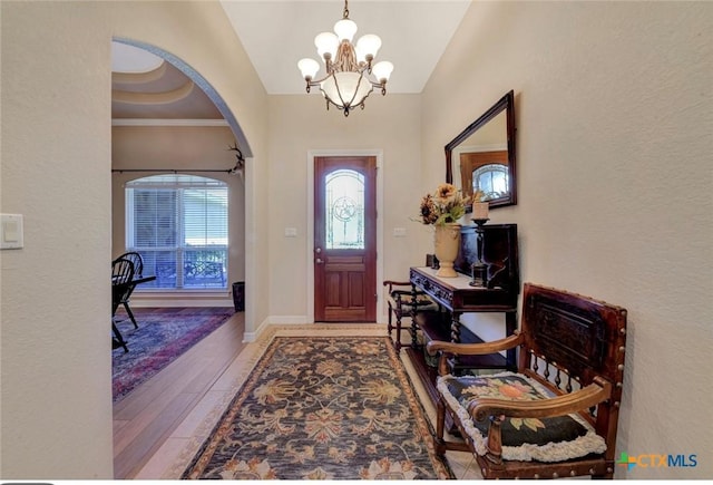 10510 Teich Loop, New Braunfels, TX 78132 - entrance foyer with arched walkways, an inviting chandelier, wood finished floors, and vaulted ceiling