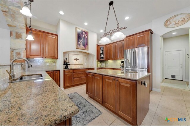 10510 Teich Loop, New Braunfels, TX 78132 - kitchen with backsplash, light stone countertops, a sink, light tile patterned floors, and freestanding refrigerator