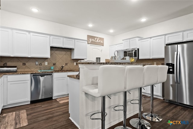 4505 Prewitt Ranch Rd, Killeen, TX 76549 - kitchen featuring appliances with stainless steel finishes, a kitchen breakfast bar, white cabinets, dark wood finished floors, and recessed lighting