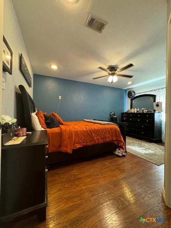 bedroom with ceiling fan and dark wood-type flooring