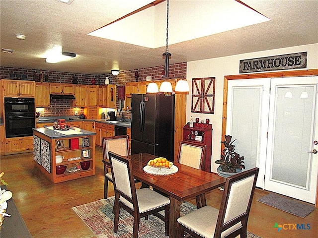 dining area featuring sink, a textured ceiling, and brick wall