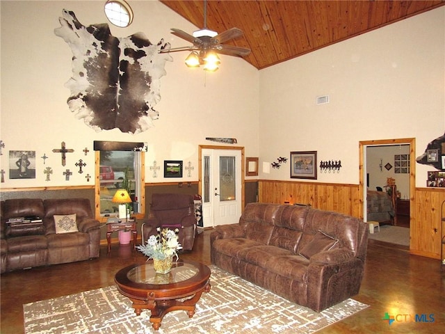 living room with wood ceiling, ceiling fan, a wainscoted wall, and visible vents