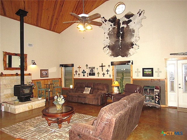 living room featuring high vaulted ceiling, wooden ceiling, a wood stove, and ceiling fan