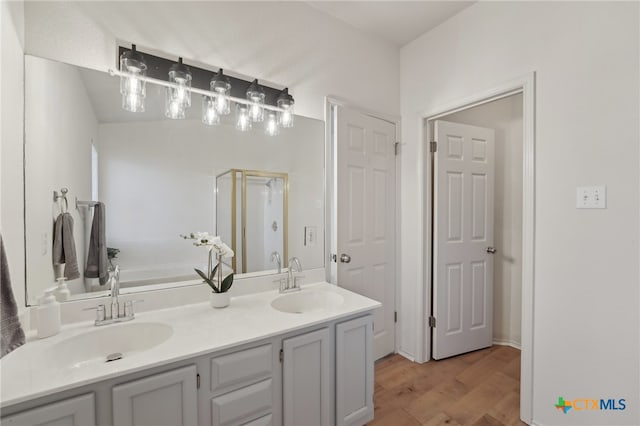 bathroom with a garden tub, wood finished floors, a shower stall, and a sink