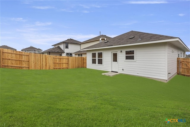 rear view of property with a yard