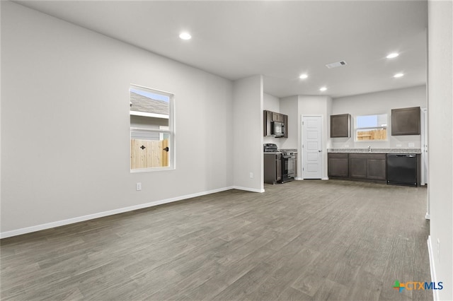 unfurnished living room with hardwood / wood-style flooring and sink