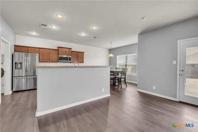 2506 Alamocitos Creek Dr, Killeen, TX 76549 - kitchen with appliances with stainless steel finishes, brown cabinets, dark wood-type flooring, recessed lighting, and hanging light fixtures