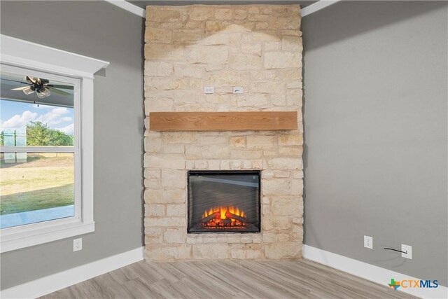 101 Dana Point Rd, Lorena, TX 76655 - detailed view of baseboards, a fireplace, wood finished floors, and a ceiling fan