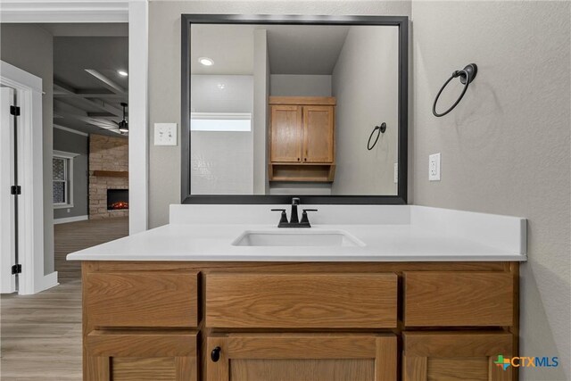 101 Dana Point Rd, Lorena, TX 76655 - bathroom featuring wood finished floors, a ceiling fan, vanity, a fireplace, and baseboards