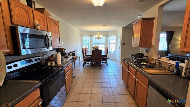 501 Mesquite Cir, Copperas Cove, TX 76522 - kitchen featuring appliances with stainless steel finishes, a chandelier, dark countertops, and brown cabinets