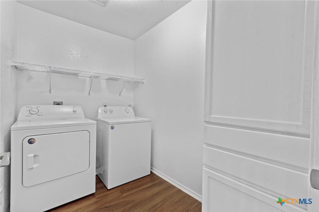 clothes washing area featuring dark hardwood / wood-style flooring and washing machine and dryer