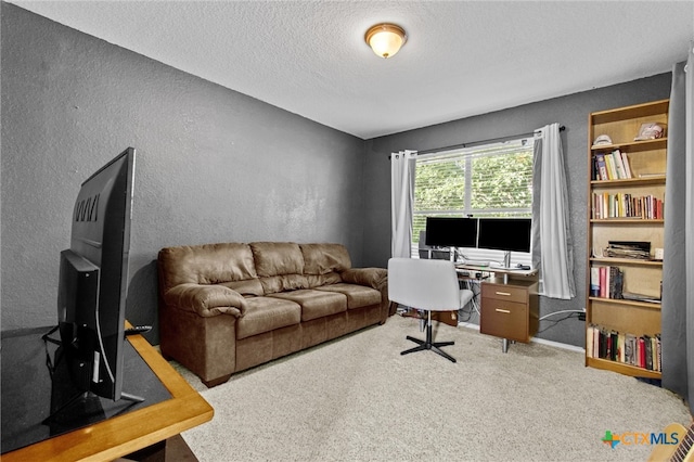 carpeted office space featuring a textured ceiling