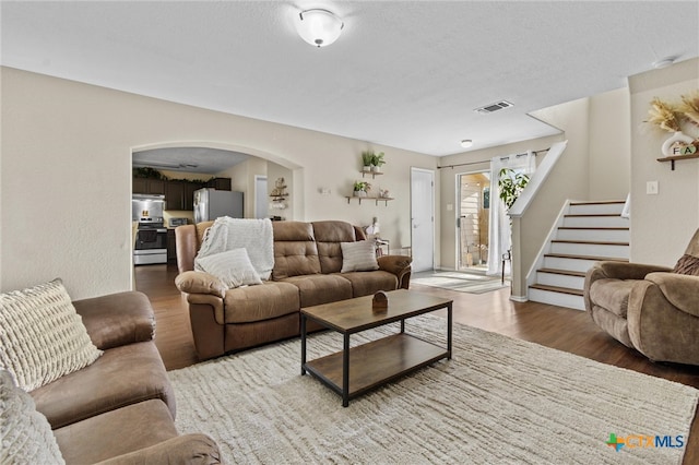 living room with a textured ceiling and hardwood / wood-style flooring