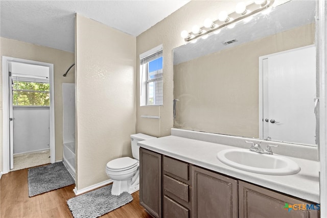 full bathroom featuring hardwood / wood-style floors, a wealth of natural light, vanity, and toilet