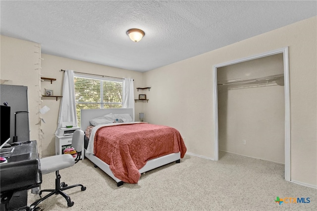 carpeted bedroom featuring a textured ceiling and a closet