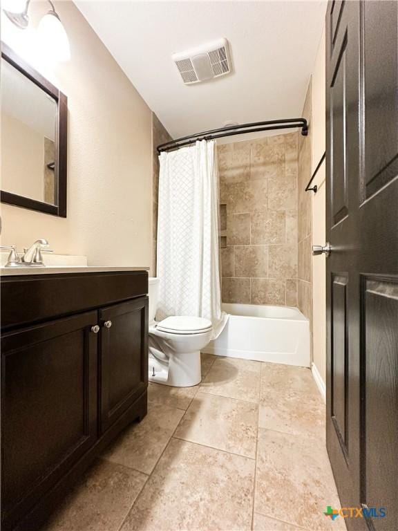 full bath featuring toilet, vanity, visible vents, tile patterned floors, and shower / bath combo