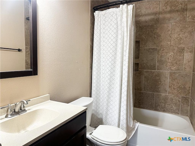 bathroom featuring toilet, a textured wall, shower / tub combo, and vanity