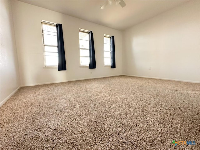 empty room featuring ceiling fan, baseboards, and vaulted ceiling