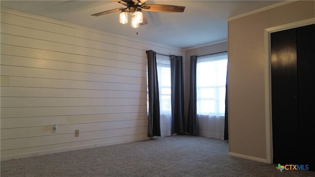 carpeted empty room featuring ornamental molding and baseboards