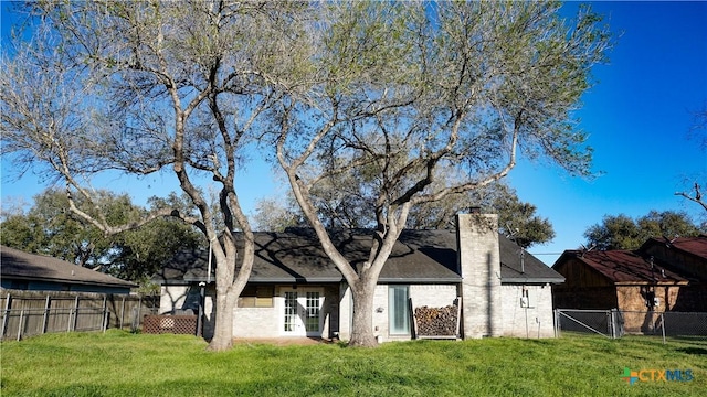 back of property featuring a yard, a chimney, and fence