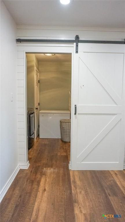 hall featuring a barn door and wood finished floors