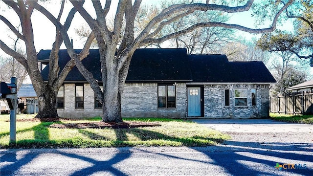 view of front of home with fence and brick siding