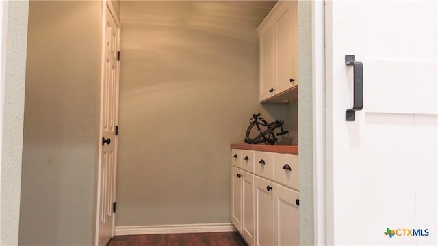 interior space with baseboards and dark wood-type flooring