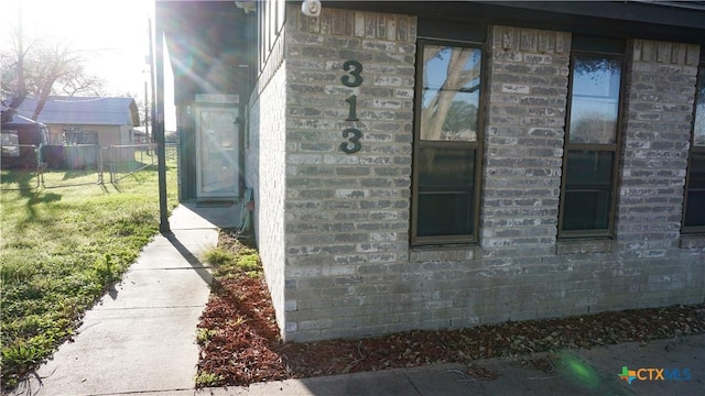 view of property exterior with fence and a lawn