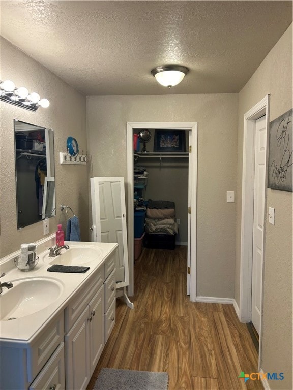 bathroom featuring hardwood / wood-style floors, vanity, and a textured ceiling