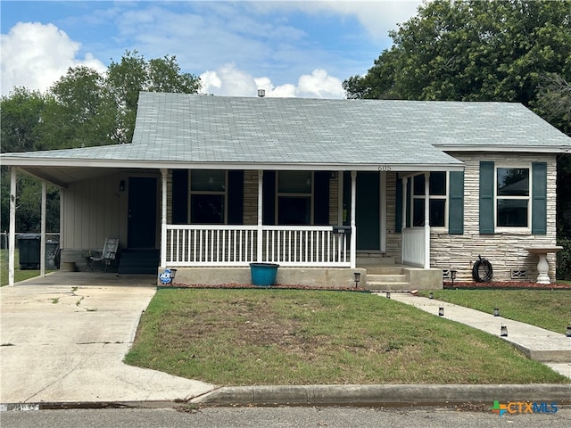 view of front of property with a front lawn, covered porch, and a carport