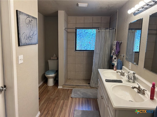 bathroom with a shower with shower curtain, hardwood / wood-style flooring, a textured ceiling, and a wealth of natural light