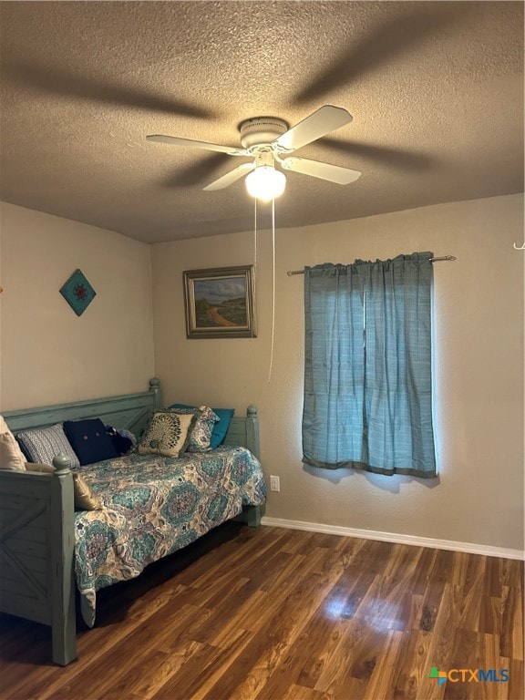 bedroom featuring dark hardwood / wood-style flooring, a textured ceiling, and ceiling fan