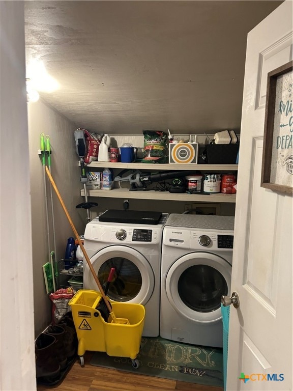 clothes washing area with wood-type flooring and independent washer and dryer