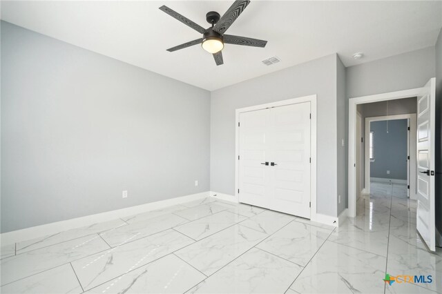 unfurnished bedroom featuring ceiling fan and a closet