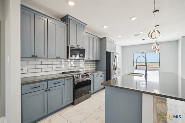 kitchen with appliances with stainless steel finishes, tasteful backsplash, pendant lighting, and sink